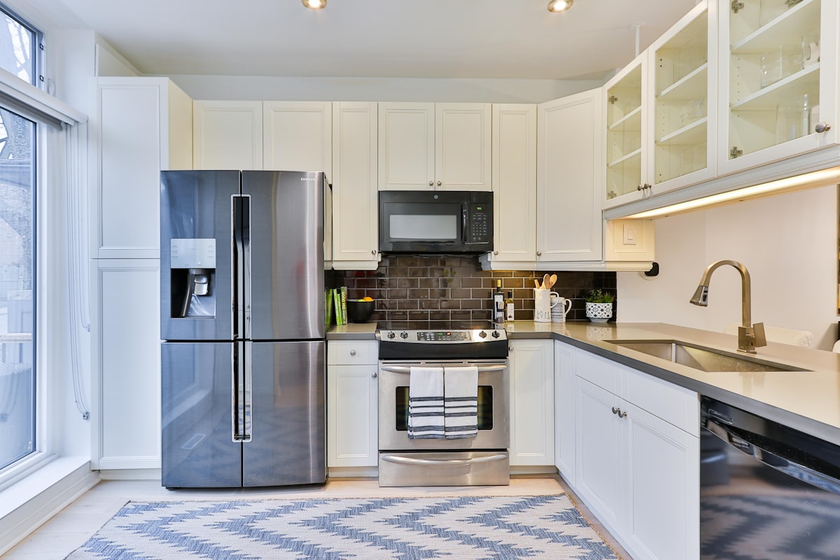 A modern Bay Harbor Islands luxury kitchen with premium stainless steel refrigerator, range, and dishwasher