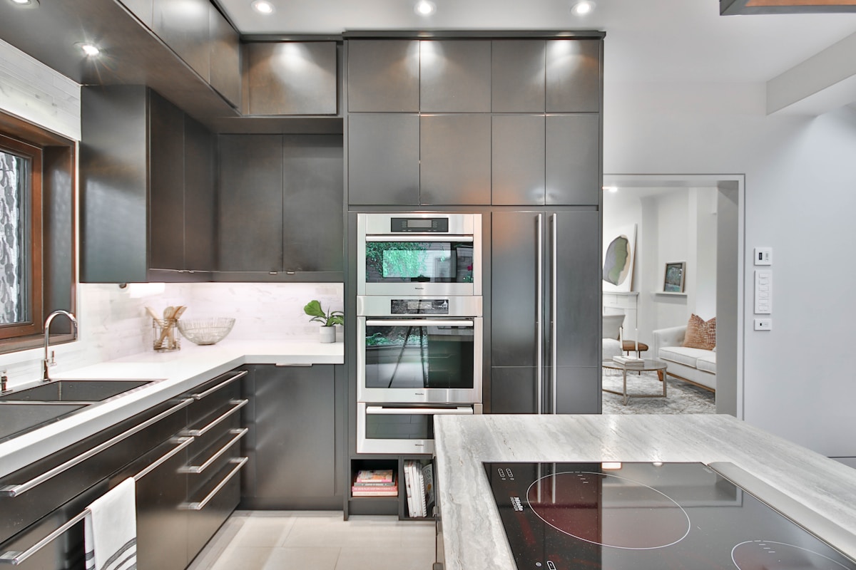 A luxury Coral Gables kitchen with a built-in stainless steel refrigerator and ice maker integrated into custom cabinetry