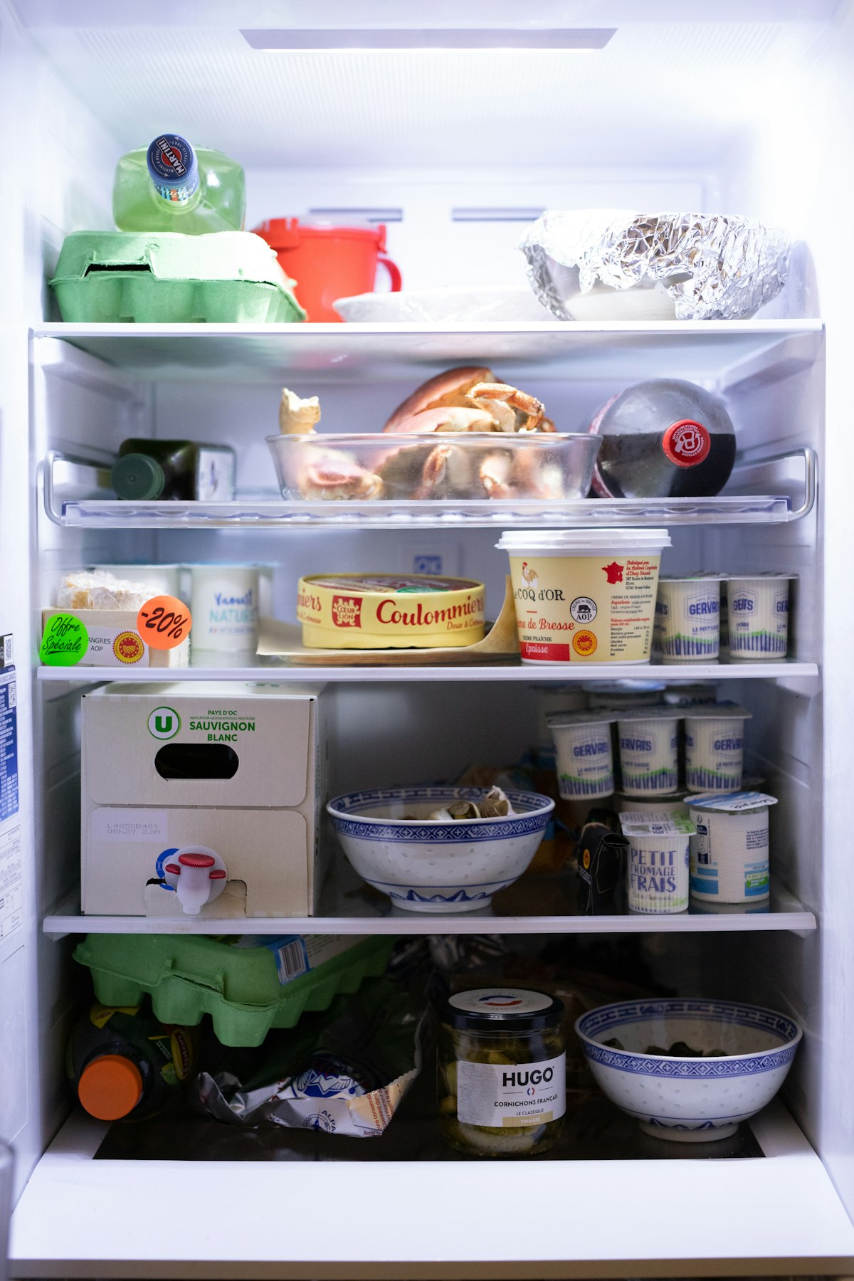 Open refrigerator stocked with food showing interior airflow and cold-air distribution