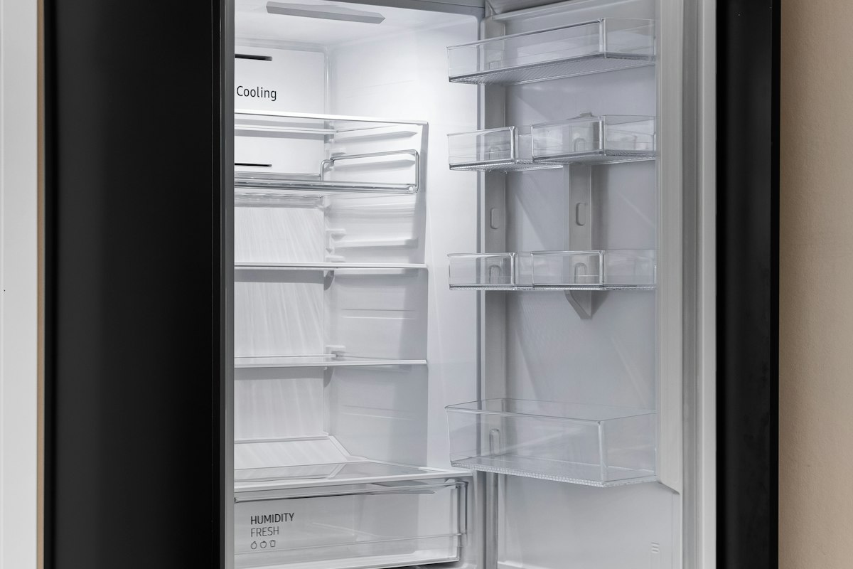 An open refrigerator with empty shelves and door bins showing the cooling and humidity fresh compartment