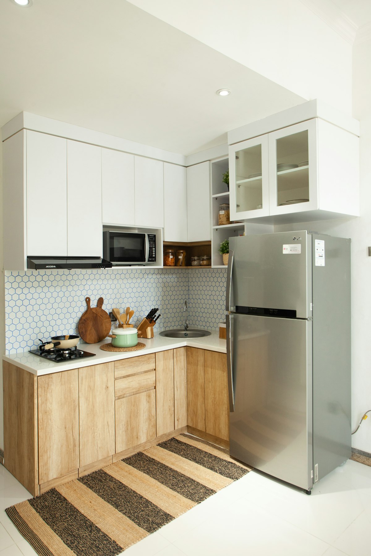 A stainless steel refrigerator and freezer installed beside a range in a Coconut Creek kitchen