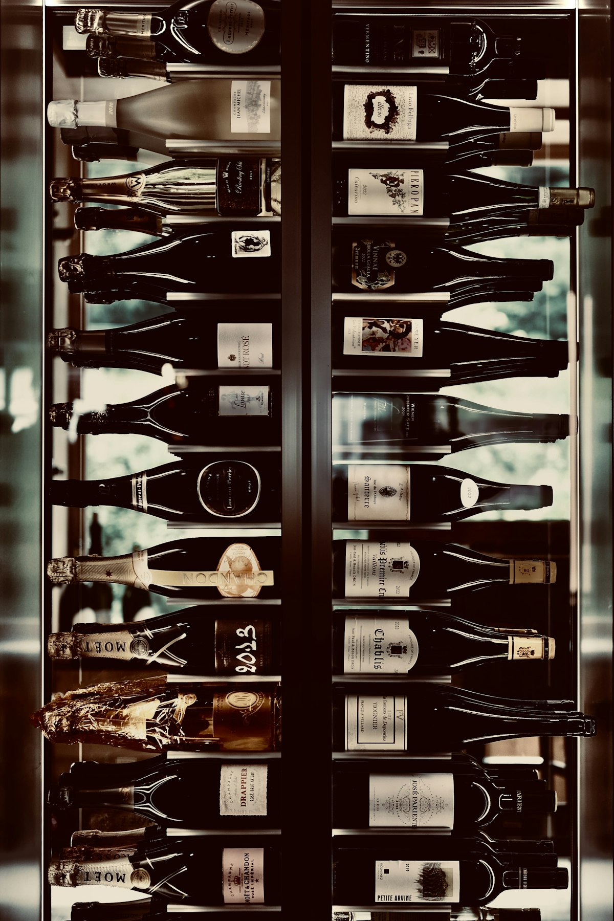 A built-in wine cooler stocked with bottles in a Fisher Island residence, holding a steady storage temperature