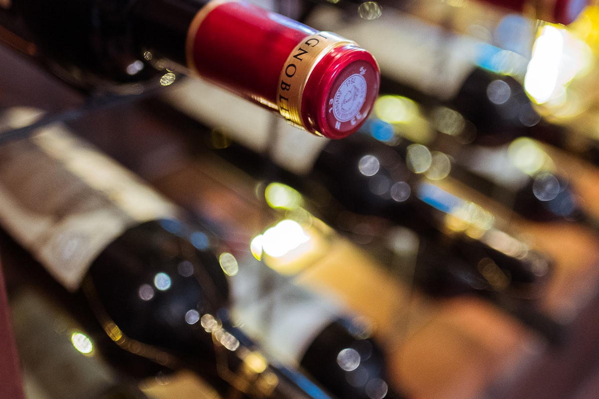 Wine bottles resting on the glass shelving of a built-in wine cooler in a Surfside home