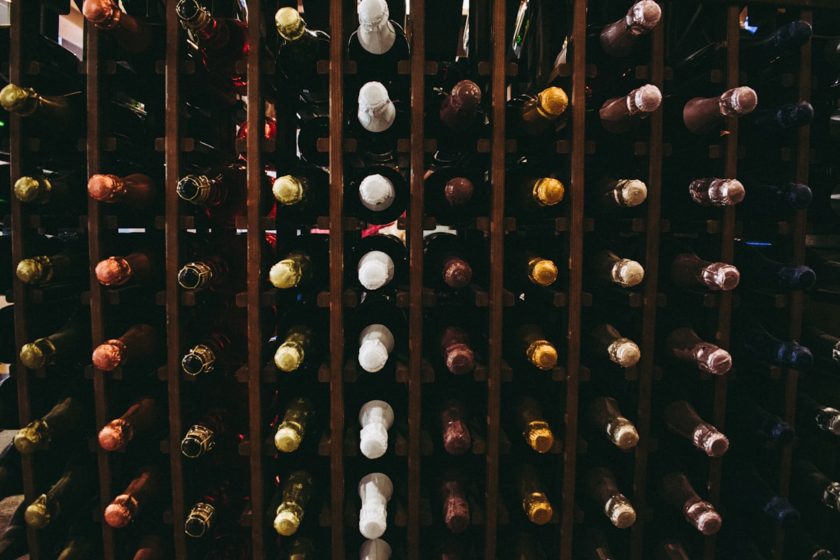 Assorted wine bottles resting horizontally on storage racks inside a climate-controlled cabinet