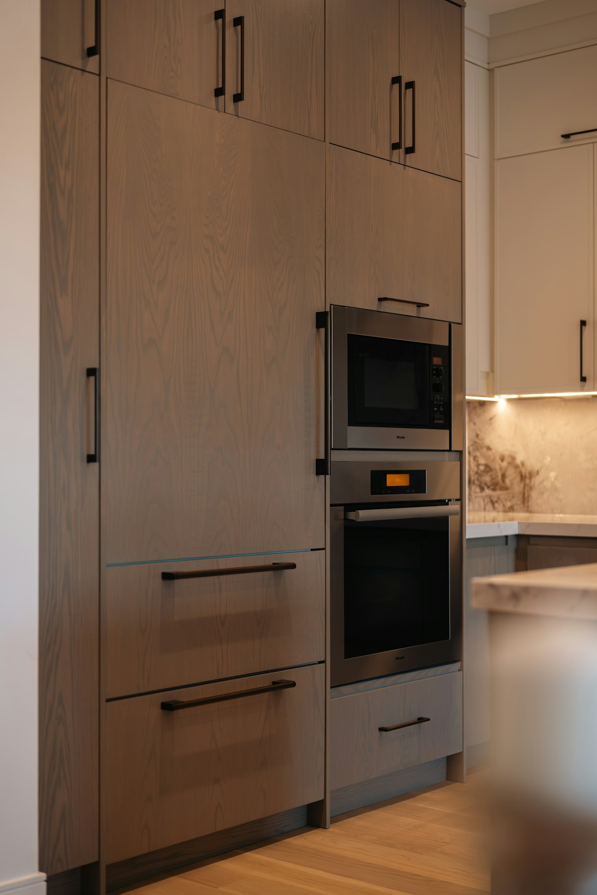 A built-in wall oven integrated into modern kitchen cabinetry in a Miami home